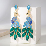 Elegant peacock-inspired dangle earrings featuring green crystal feather accents.